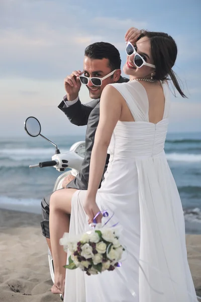 Pareja recién casada en el paseo por la playa scooter blanco — Foto de Stock