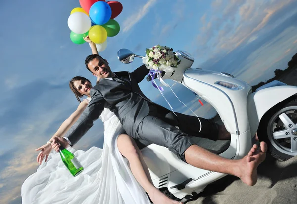 Pareja recién casada en el paseo por la playa scooter blanco —  Fotos de Stock