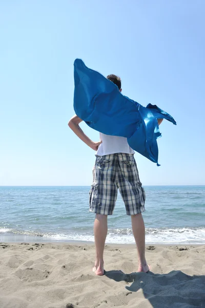 Lustiger Superheld steht am Strand — Stockfoto