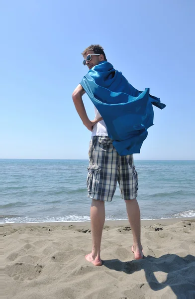 Srandovní superhrdina stojící na pláži — Stock fotografie