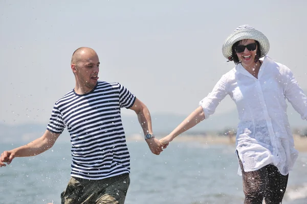 Feliz jovem casal tem tempo romântico na praia — Fotografia de Stock