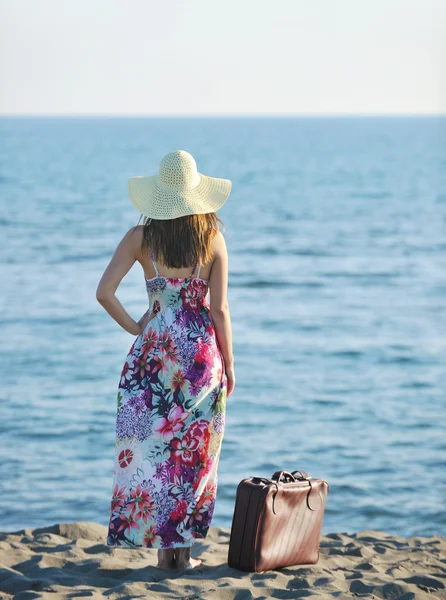 Frau mit Koffer am Strand — Stockfoto