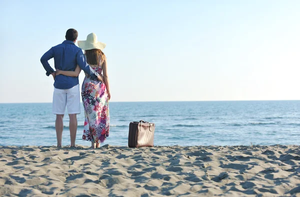 Пара на пляжі з дорожньою сумкою — стокове фото