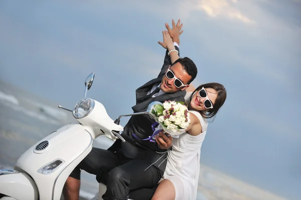 Just married couple on the beach ride white scooter Royalty Free Stock Photos