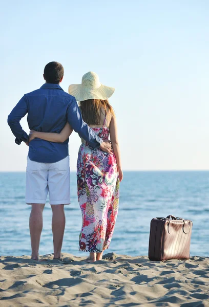 Pár na pláži s cestovní taškou — Stock fotografie