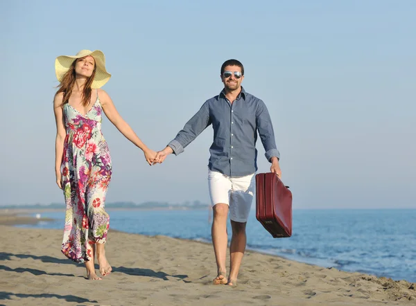 Para na plaży z torbą podróżną — Zdjęcie stockowe