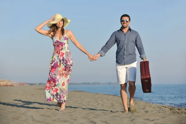 Couple sur la plage avec sac de voyage — Photo
