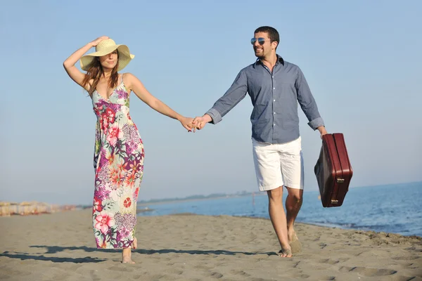 Paar am Strand mit Reisetasche — Stockfoto