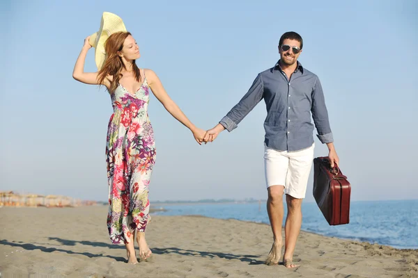 Paar am Strand mit Reisetasche — Stockfoto