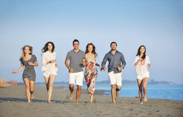 Счастливая молодая группа веселится на пляже — стоковое фото
