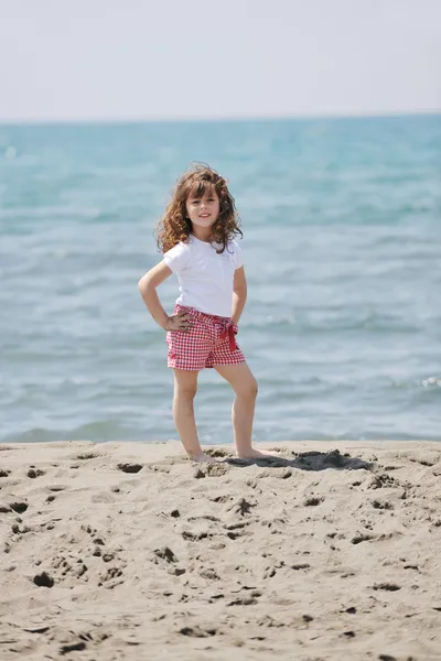 Lilla flickebarn stående på stranden — Stockfoto