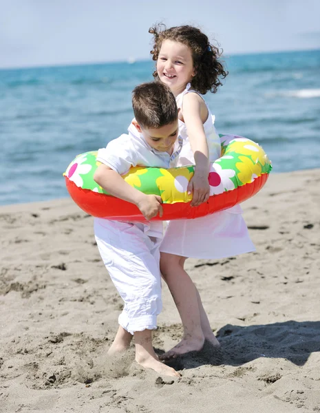 Lyckligt barn gruppen spelar på stranden — Stockfoto