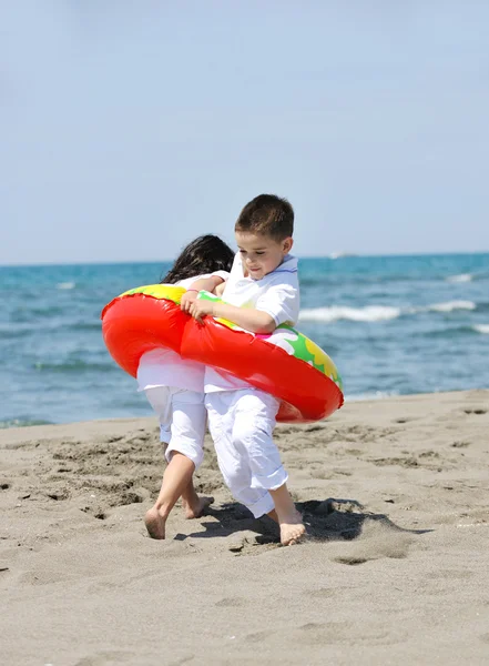 Счастливая детская группа играет на пляже — стоковое фото
