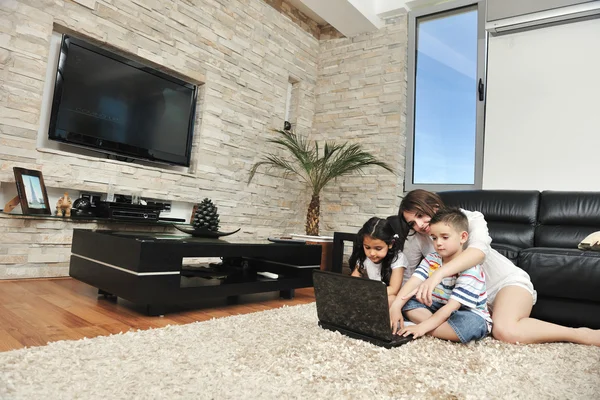 Glückliche junge Familie hat Spaß und arbeitet zu Hause am Laptop — Stockfoto