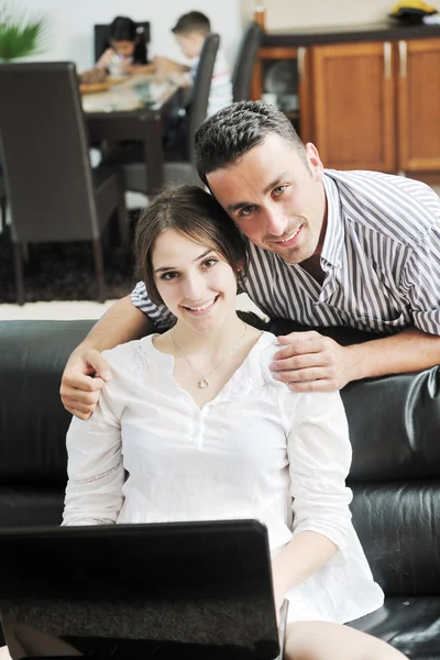 Boldog, fiatal családi szórakozást és a munka a laptop otthon — Stock Fotó