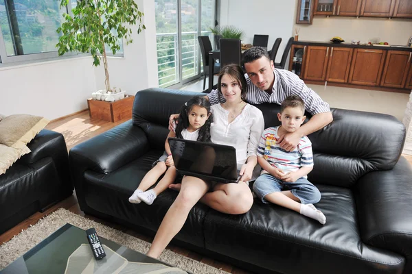 Felice giovane famiglia divertirsi e lavorare sul computer portatile a casa — Foto Stock