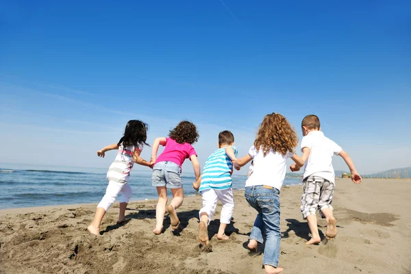Happy child group playing on beach Stock Image