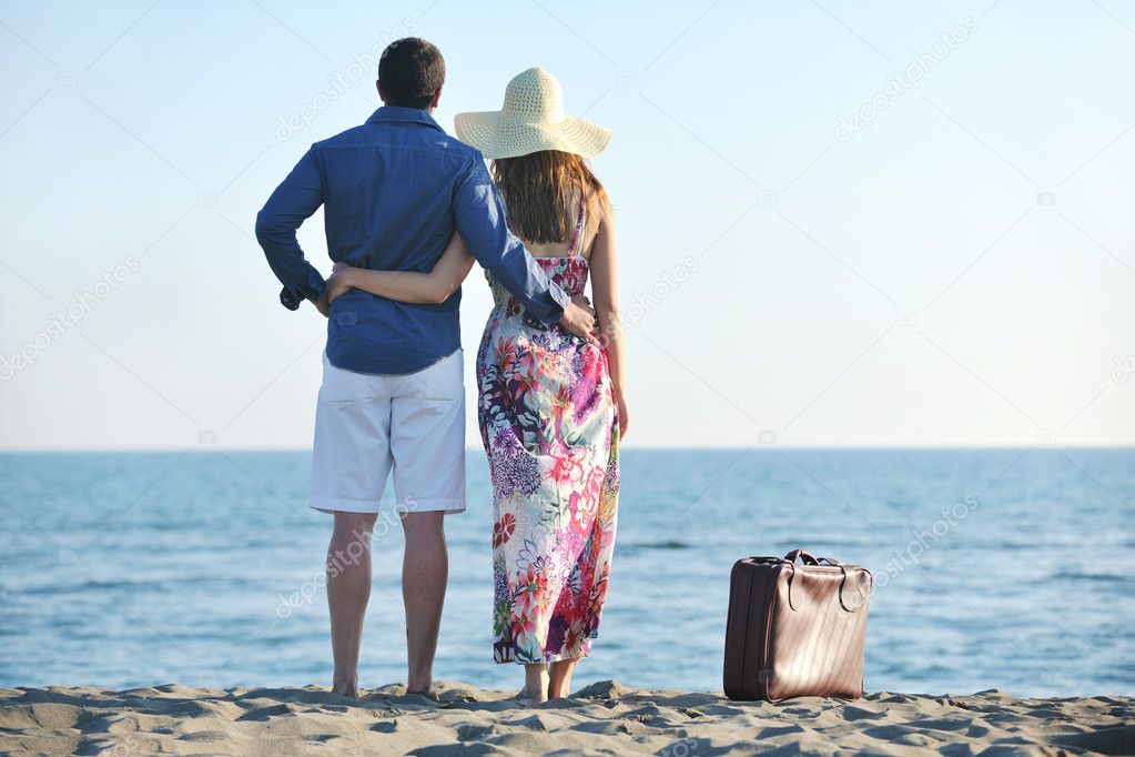 Couple on beach with travel bag