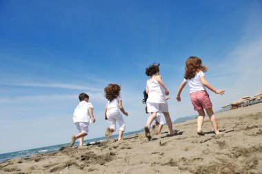 Kumsalda oynarken mutlu çocuk grubu