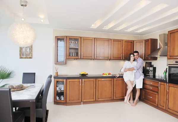 Feliz pareja joven se divierten en la cocina moderna — Foto de Stock