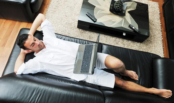 Portret spokojny młody facet korzysta z laptopa w domu — Zdjęcie stockowe