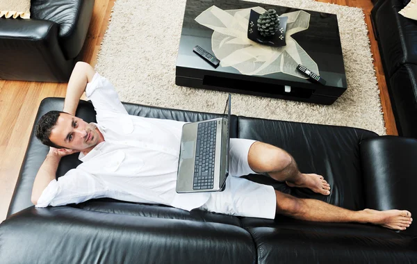 Портрет розслабленого молодого хлопця, який використовує ноутбук вдома — стокове фото