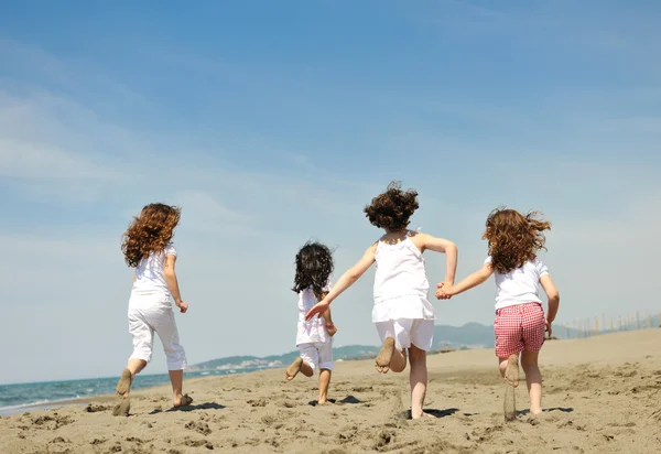 Fröhliche Kindergruppe spielt am Strand — Stockfoto
