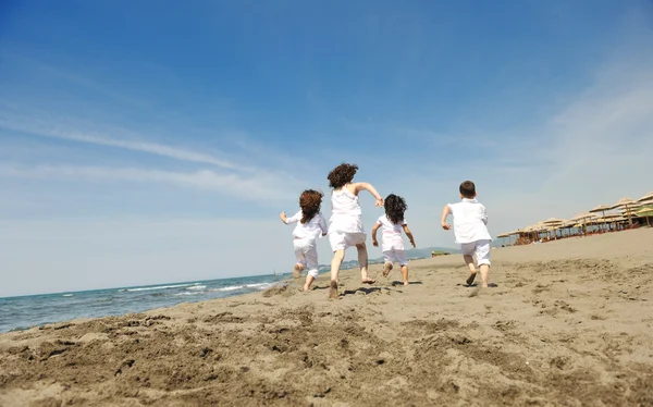 Gelukkig kind groep spelen op strand — Stockfoto