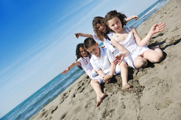Ευτυχισμένη παιδική ομάδα που παίζει στην παραλία — Φωτογραφία Αρχείου