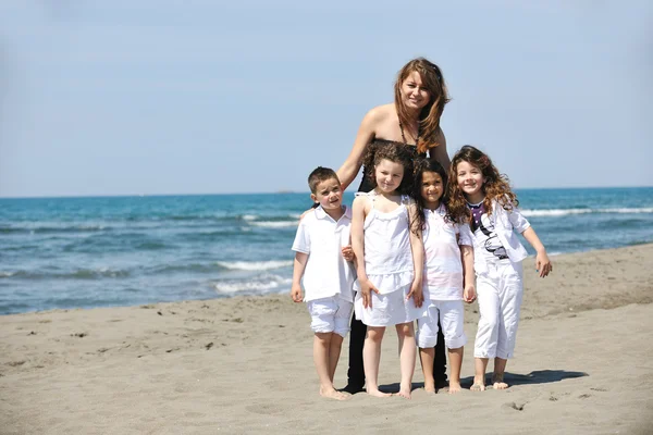Group portrait of childrens with teacher on beach — Stock Photo, Image