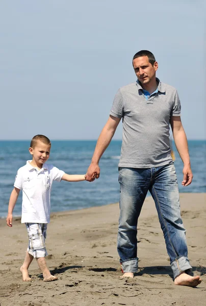 Счастливые отец и сын весело проводят время на пляже — стоковое фото