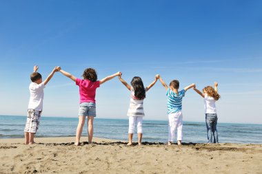 Kumsalda oynarken mutlu çocuk grubu