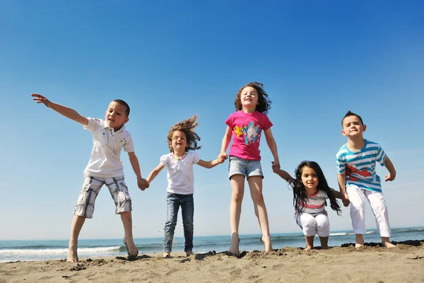 Happy child group playing on beach Stock Photo