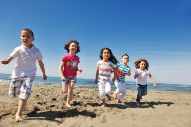 Happy child group playing on beach clipart