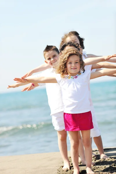 Fröhliche Kindergruppe spielt am Strand — Stockfoto