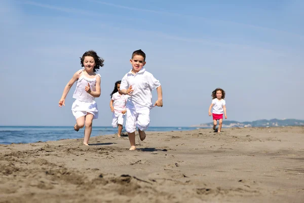 Gelukkig kind groep spelen op strand — Stockfoto