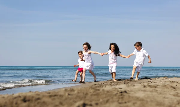 Feliz grupo de niños jugando en la playa —  Fotos de Stock