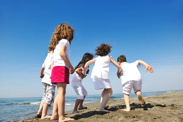 Grupo criança feliz brincando na praia — Fotografia de Stock