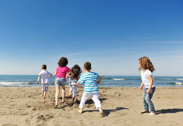 Groupe d'enfants heureux jouant sur la plage — Photo
