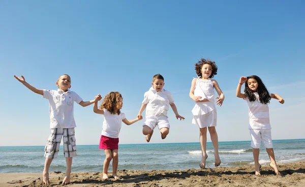 Happy child group playing on beach Stock Picture