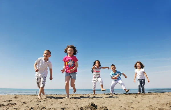 Happy child group playing on beach Stock Image