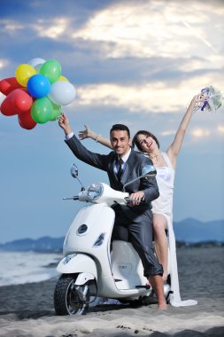 Just married couple on the beach ride white scooter clipart