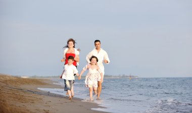 Mutlu genç aile sahilde eğleniyor.