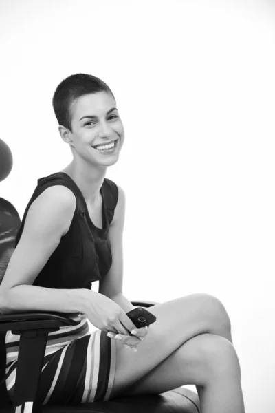 Bruneta modelka pózuje na židli obchodních — Stock fotografie