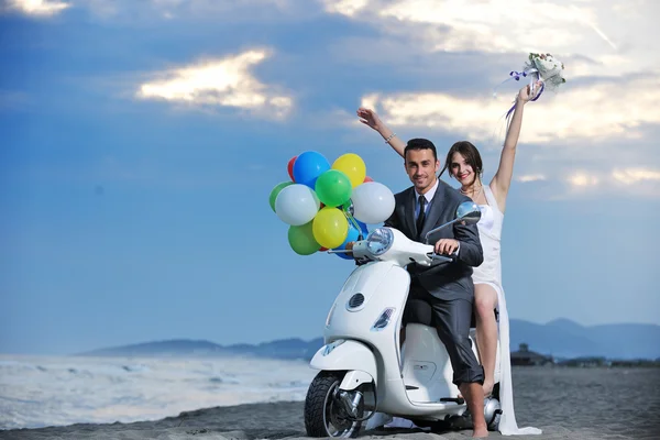 Coppia appena sposata sul giro in spiaggia scooter bianco — Foto Stock