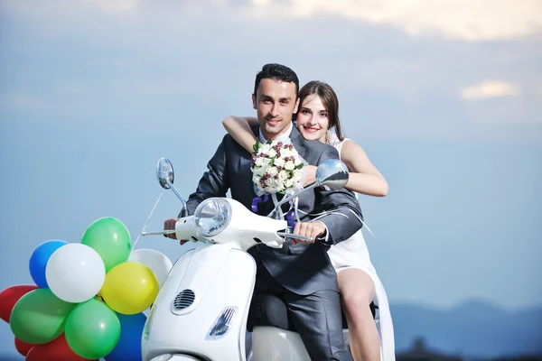 Просто подружня пара на пляжі їздить білим скутером — стокове фото