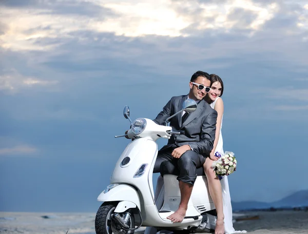 Coppia appena sposata sul giro in spiaggia scooter bianco — Foto Stock