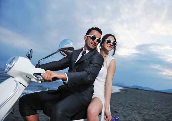 Pareja recién casada en el paseo por la playa scooter blanco —  Fotos de Stock