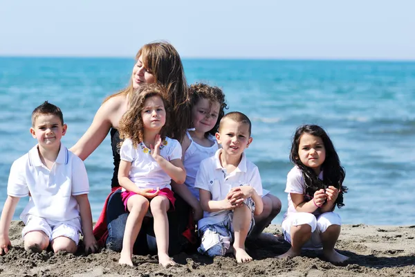 Group portrait of childrens with teacher on beach — Stock Photo, Image