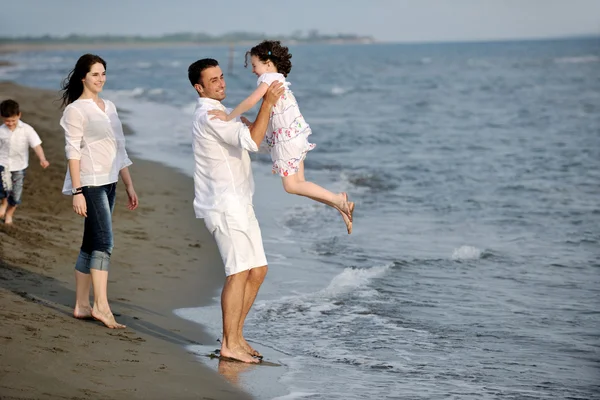 Lycklig ung familj ha kul på stranden — Stockfoto